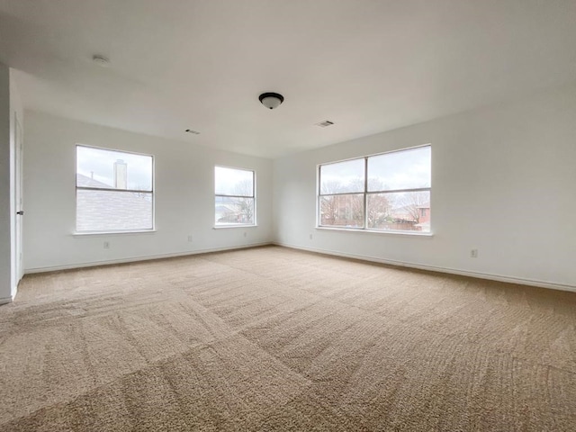 spare room with baseboards, carpet floors, and visible vents