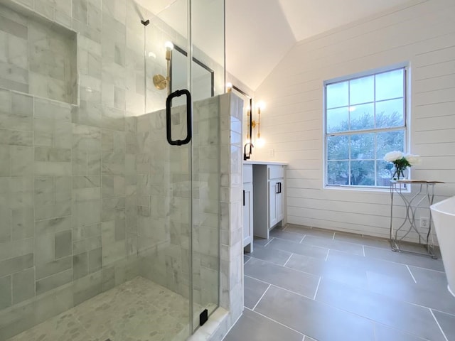 bathroom featuring vanity, lofted ceiling, a freestanding bath, a shower stall, and tile patterned floors