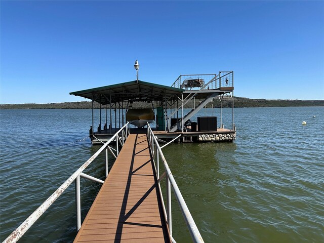 view of dock with cooling unit, a water view, and boat lift