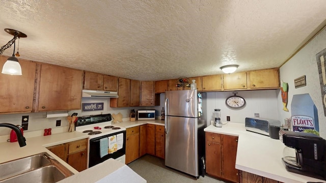 kitchen featuring range with electric cooktop, under cabinet range hood, freestanding refrigerator, brown cabinetry, and a sink