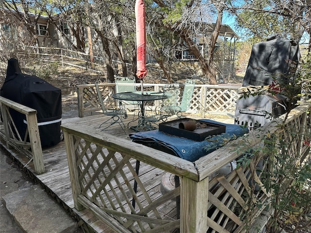 wooden deck featuring outdoor dining space and area for grilling