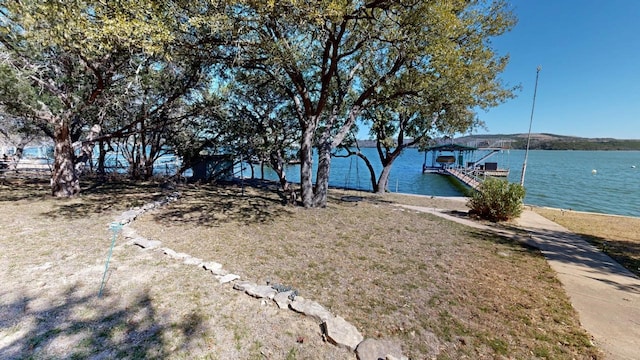 view of yard with a dock and a water view