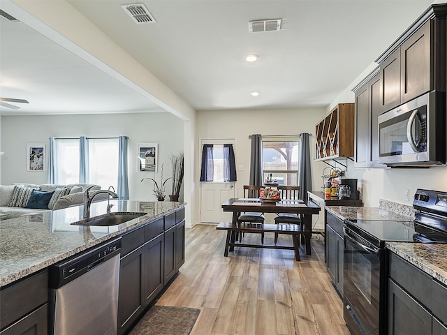 kitchen featuring light wood finished floors, visible vents, appliances with stainless steel finishes, and a sink