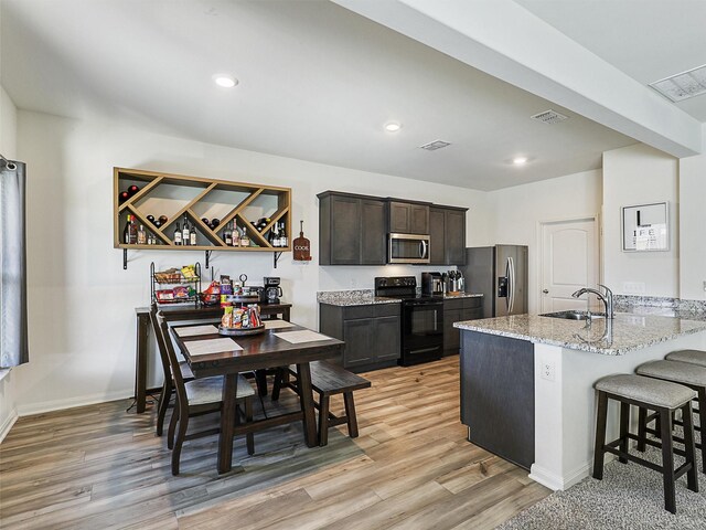 kitchen featuring visible vents, stainless steel appliances, light wood-type flooring, and a sink