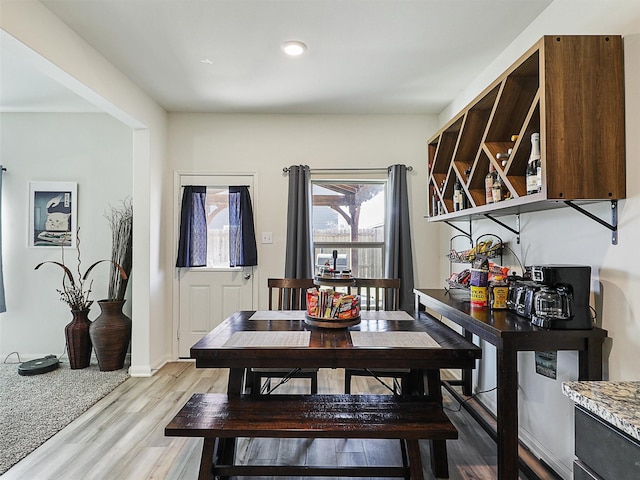 dining space featuring light wood-type flooring and baseboards