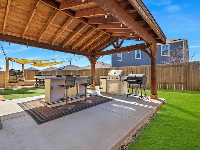 view of patio with a gazebo, grilling area, a fenced backyard, and outdoor dry bar