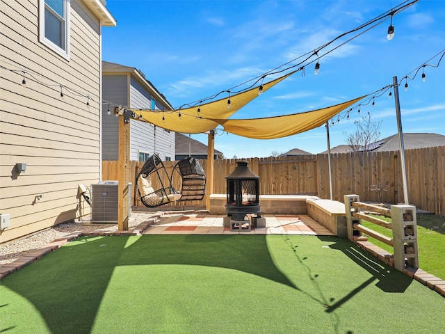 view of yard featuring central air condition unit, a fenced backyard, and a patio area