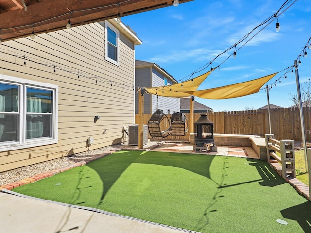 view of yard with a patio, fence, and central AC