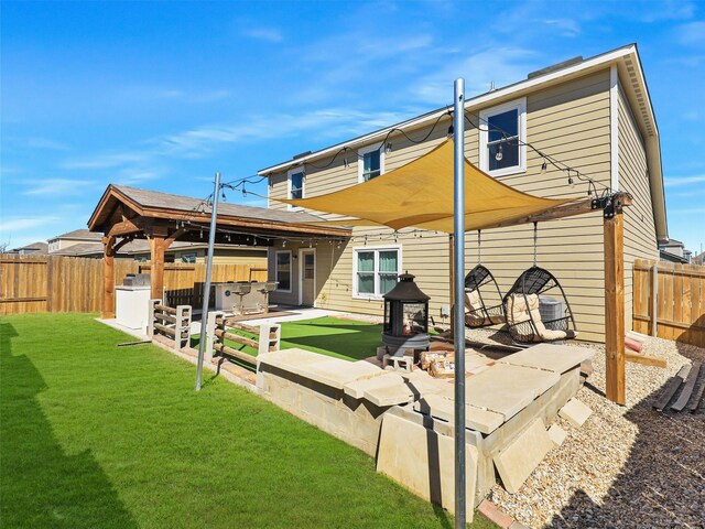 rear view of house with a gazebo, a lawn, a patio, and a fenced backyard