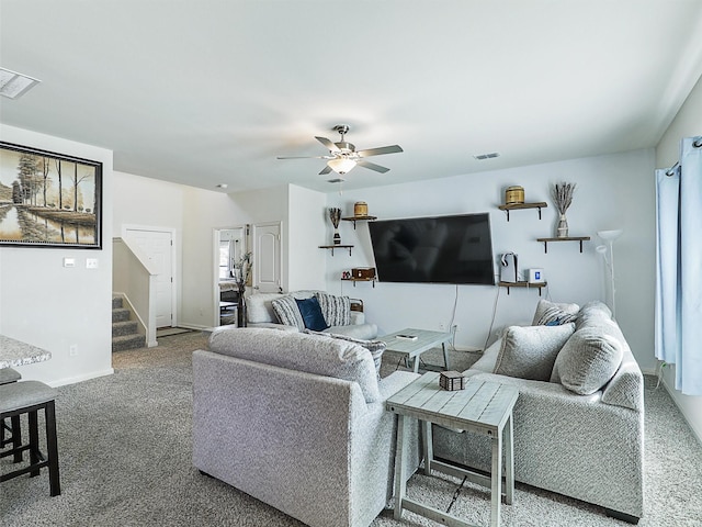 carpeted living room with stairway, a ceiling fan, visible vents, and baseboards