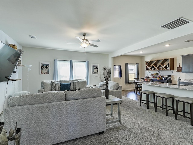 living area featuring recessed lighting, a ceiling fan, visible vents, and dark wood-style flooring