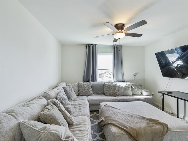 living area featuring baseboards and a ceiling fan