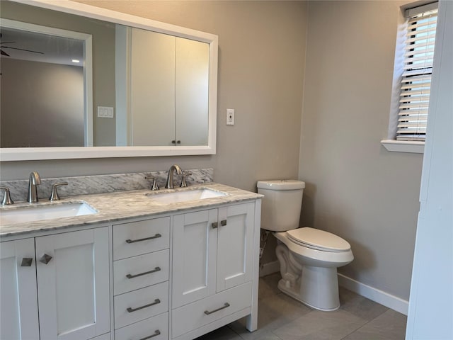 bathroom featuring a sink, a ceiling fan, toilet, and double vanity