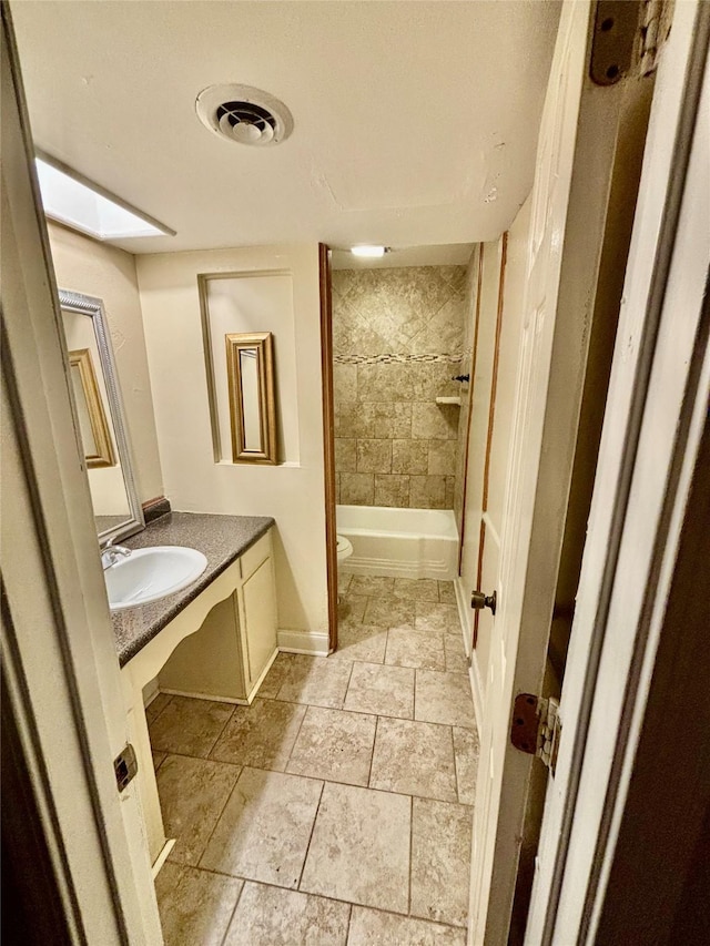 full bathroom with visible vents, toilet, shower / bath combination, a skylight, and vanity