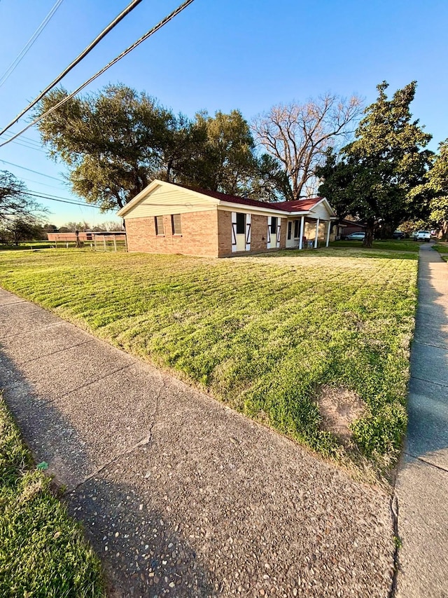 view of front of house with a front yard and brick siding