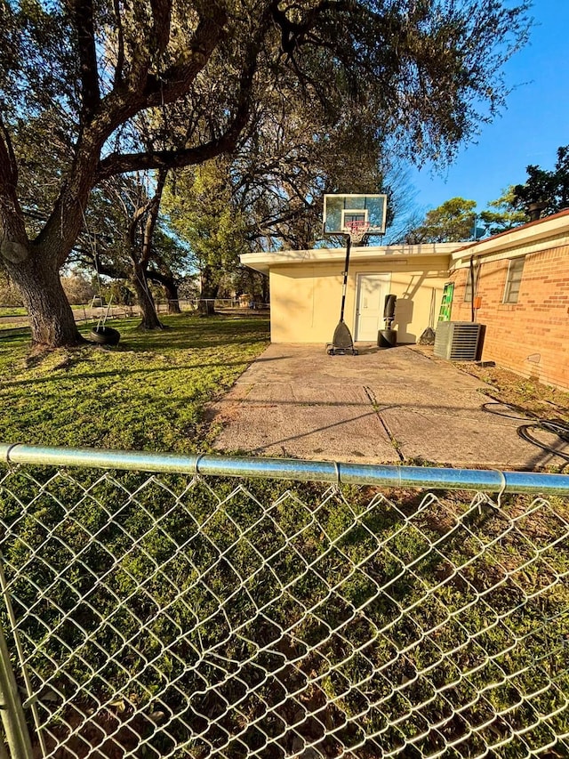 view of basketball court with a yard