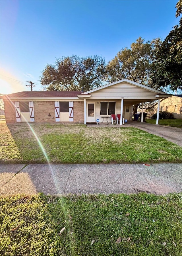 view of front of property with a front yard, a carport, and driveway