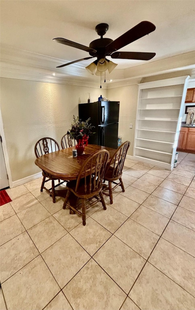 dining space with light tile patterned floors, baseboards, ceiling fan, and crown molding