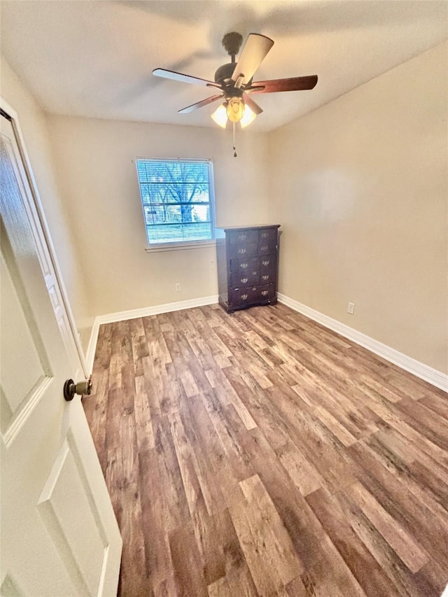 spare room with a ceiling fan, baseboards, and wood finished floors