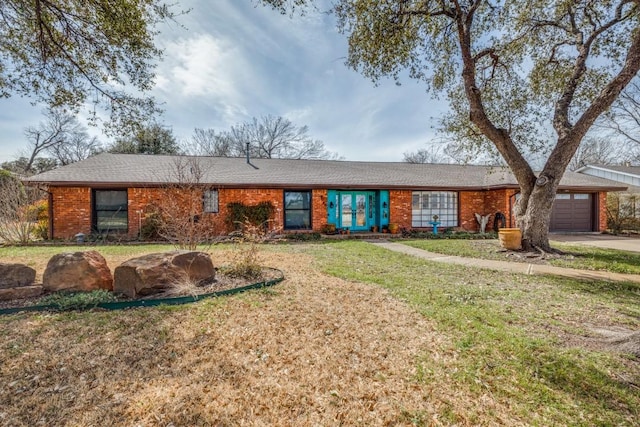 single story home with a front lawn, a garage, and brick siding