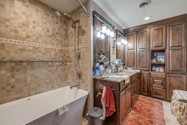 bathroom featuring walk in shower, a freestanding tub, visible vents, and vanity