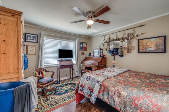 bedroom with ceiling fan, baseboards, wood finished floors, and crown molding