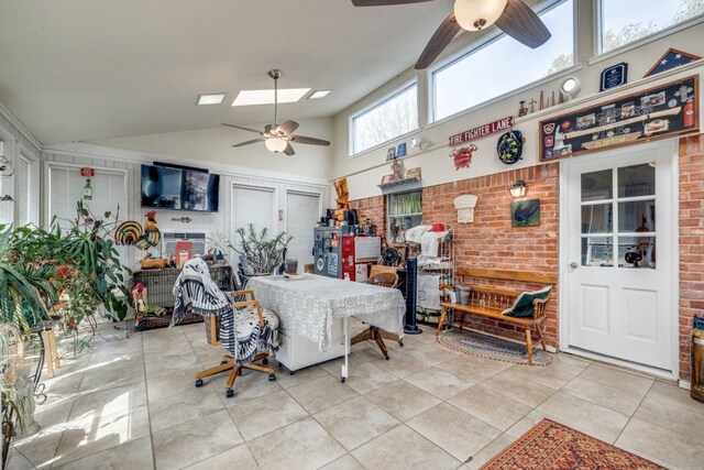 tiled dining room with brick wall, high vaulted ceiling, and a ceiling fan