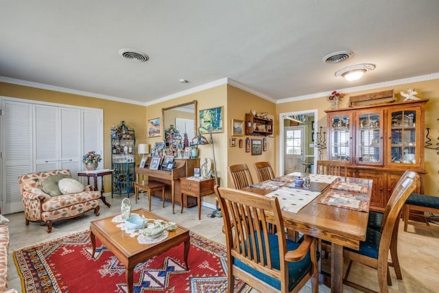 dining room with light tile patterned floors, visible vents, and ornamental molding