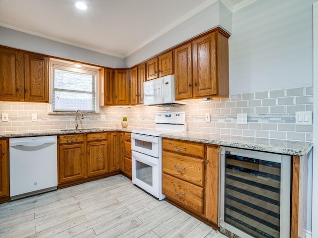 kitchen featuring white appliances, wine cooler, brown cabinets, and a sink