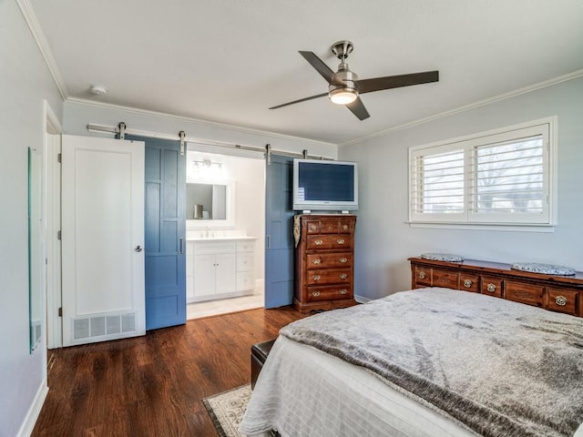 bedroom featuring visible vents, a barn door, wood finished floors, and crown molding