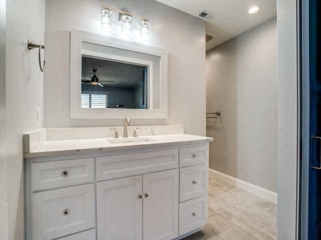 bathroom featuring visible vents, baseboards, and vanity