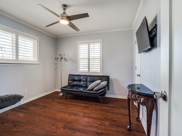 sitting room with ceiling fan, wood finished floors, baseboards, and ornamental molding