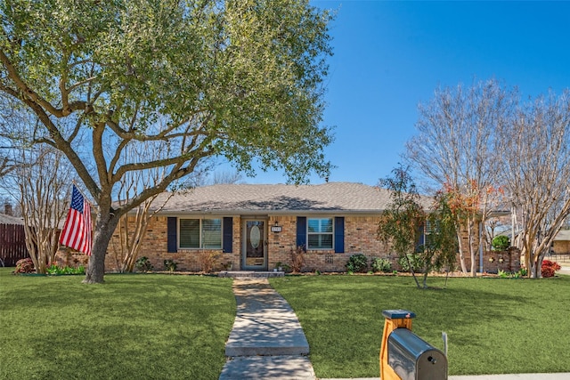 single story home with brick siding, roof with shingles, a front yard, and fence