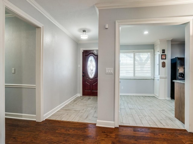 foyer featuring crown molding, parquet floors, baseboards, and a wealth of natural light