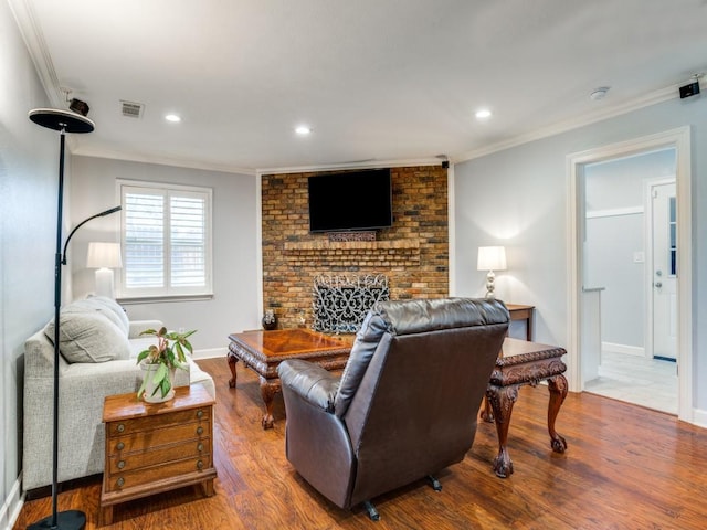 living area featuring a fireplace, crown molding, recessed lighting, and wood finished floors