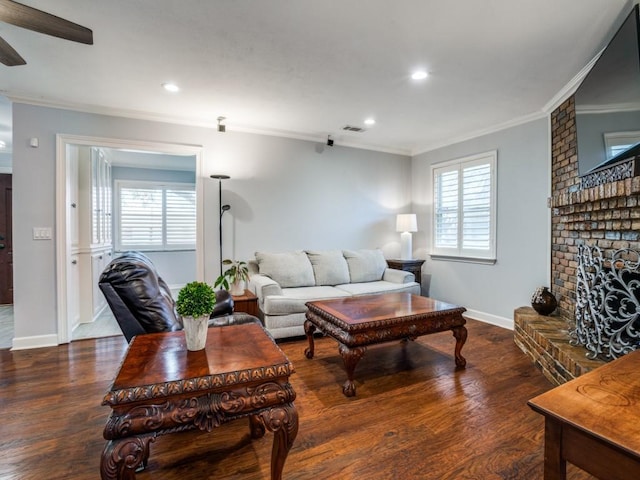 living room featuring a brick fireplace, a healthy amount of sunlight, and wood finished floors