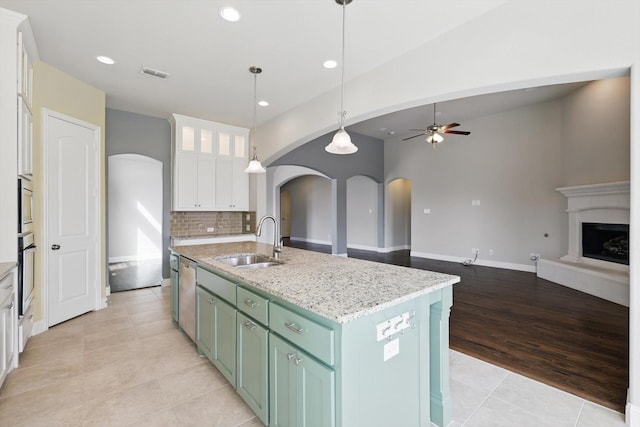 kitchen with visible vents, a sink, white cabinetry, arched walkways, and appliances with stainless steel finishes