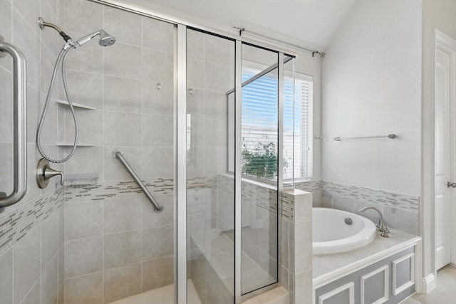 bathroom featuring a bath, a shower stall, and vaulted ceiling