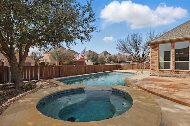 view of swimming pool featuring a patio, a fenced backyard, and a pool with connected hot tub