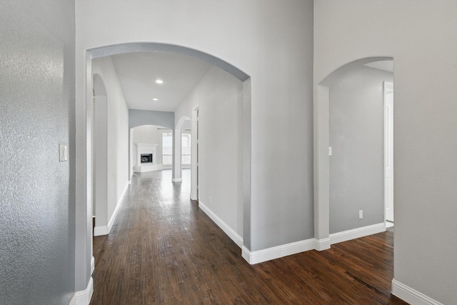 hall with recessed lighting, baseboards, and wood-type flooring