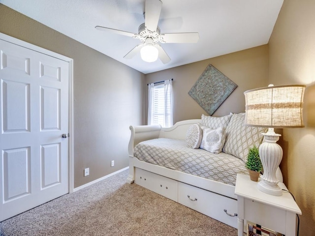 carpeted bedroom featuring baseboards and a ceiling fan