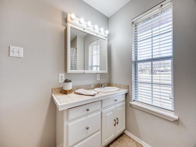 bathroom with vanity, baseboards, and tile patterned flooring