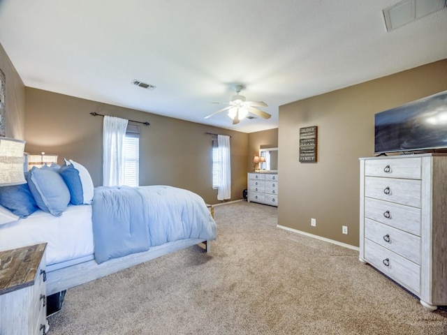 carpeted bedroom featuring visible vents, baseboards, and a ceiling fan