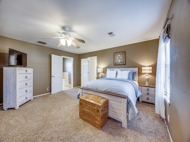 carpeted bedroom featuring visible vents, baseboards, and ensuite bathroom