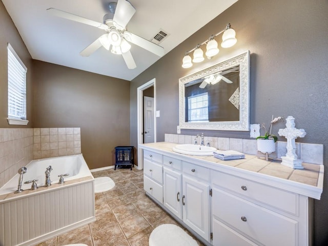 bathroom featuring visible vents, a ceiling fan, a bath, and vanity