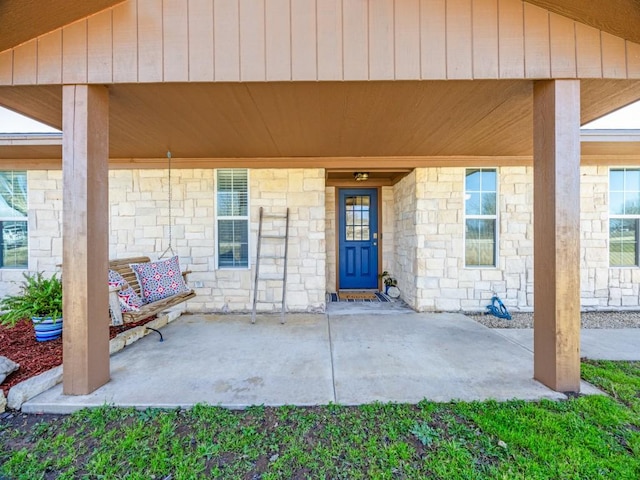 property entrance with stone siding and covered porch