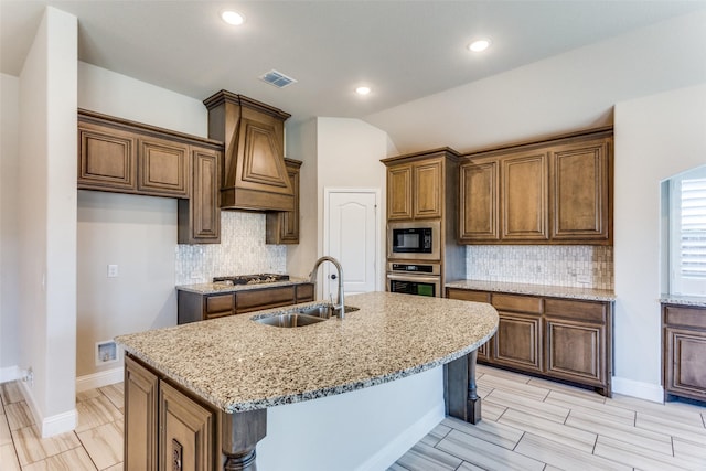 kitchen featuring visible vents, custom exhaust hood, lofted ceiling, a sink, and stainless steel appliances