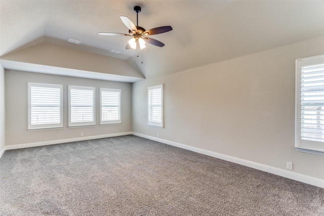 unfurnished room with visible vents, a healthy amount of sunlight, ceiling fan, and vaulted ceiling