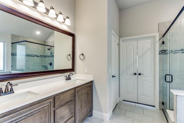 full bathroom with double vanity, a shower stall, and a sink