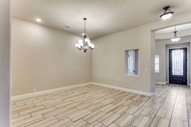 foyer entrance with visible vents, an inviting chandelier, and baseboards